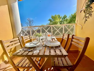 a wooden table with plates and glasses on a balcony at GATU LUCIA 3dormit 2 baños terraza aire acc 