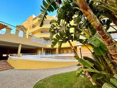 a yellow building with a boat in front of it at GATU LUCIA 3dormit 2 baños terraza aire acc 