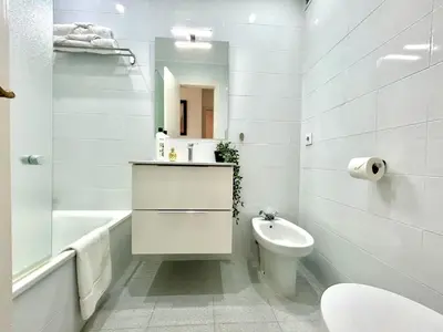 a white bathroom with a toilet and a sink at GATU LUCIA 3dormit 2 baños terraza aire acc 