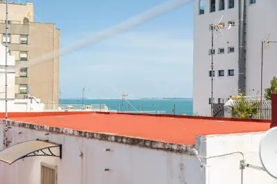 a red roof on a building with the ocean in the background at Loft/Attic, Sea Views, Private Terrace in Cádiz