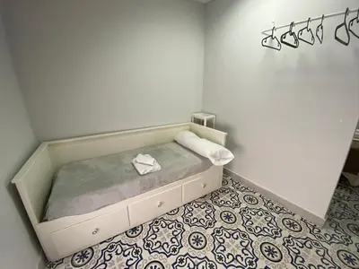 a small bed in a room with a floor at Central train station appartament in Jerez de la Frontera