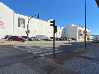 an empty street with cars parked in a parking lot at Central train station appartament in Jerez de la Frontera