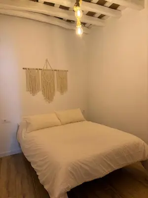 a bedroom with a bed in a room with a ceiling at Herrete Rooms in Medina Sidonia