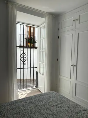 a bedroom with a bed and a large window at Herrete Rooms in Medina Sidonia