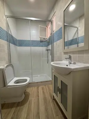 a bathroom with a toilet and a sink and a shower at Herrete Rooms in Medina Sidonia