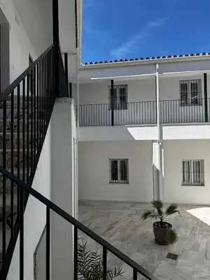 a white building with a staircase and a potted plant at Karisma Alcázar in Jerez de la Frontera