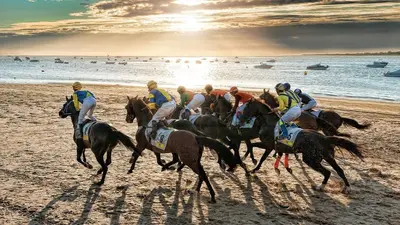 a group of people riding horses on the beach at Apartamento Jardines de la Duquesa con garaje in Sanlúcar de Barrameda