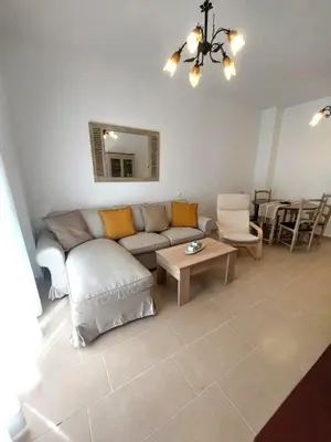 a living room with a couch and a table at Apartamento Jardines de la Duquesa con garaje in Sanlúcar de Barrameda