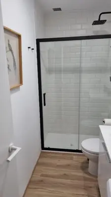 a bathroom with a glass shower and a toilet at Apartamento en Residencial la Caracola en playa la Barrosa in Novo Sancti Petri