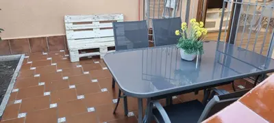 a glass table with a potted plant on a patio at Apartamento en Residencial la Caracola en playa la Barrosa in Novo Sancti Petri