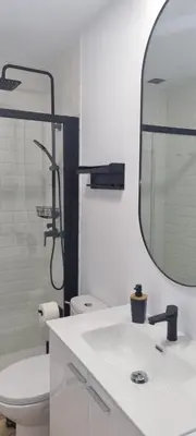 a bathroom with a toilet and a sink and a mirror at Apartamento en Residencial la Caracola en playa la Barrosa in Novo Sancti Petri