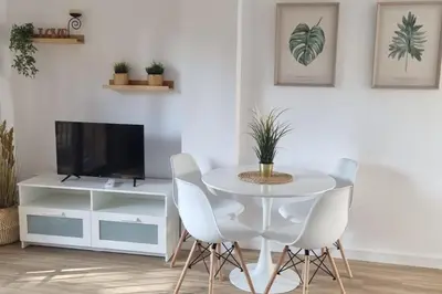 a dining room with a white table and chairs at Apartamento en Residencial la Caracola en playa la Barrosa in Novo Sancti Petri