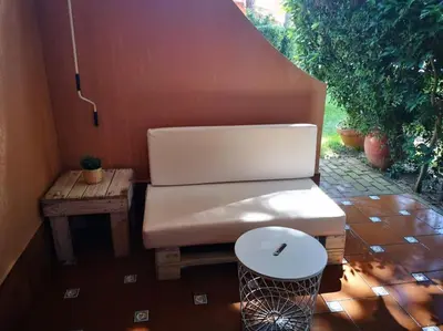 a couch sitting on a patio with a table at Apartamento en Residencial la Caracola en playa la Barrosa in Novo Sancti Petri