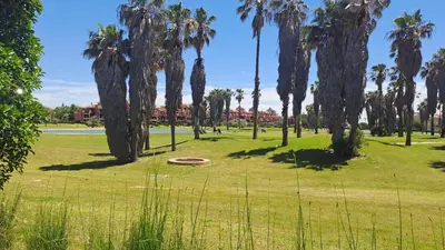 a park with palm trees and a circle in the grass at Costa Ballena Casa, pie playa y golf in Costa Ballena