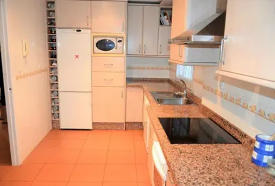 a small kitchen with a sink and a refrigerator at Costa Ballena Casa, pie playa y golf in Costa Ballena