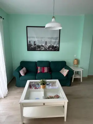a living room with a couch and a coffee table at LA CASA DE LOS PATOS Jardines del lago in Costa de Sanlúcar