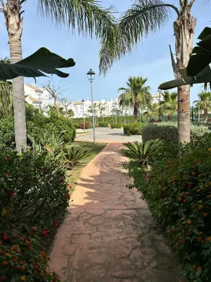 a path with palm trees and a street light at LA CASA DE LOS PATOS Jardines del lago in Costa de Sanlúcar