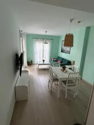 a living room with a white table and chairs at LA CASA DE LOS PATOS Jardines del lago in Costa de Sanlúcar