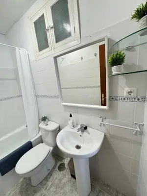 a white bathroom with a toilet and a sink at Cabildo 3 in Sanlúcar de Barrameda
