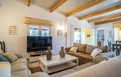 a living room with a couch and a tv at Nice Home In Chiclana De La Fronter in Novo Sancti Petri