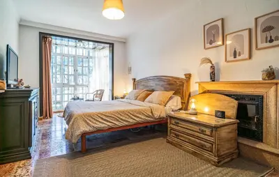 a bedroom with a bed and a fireplace at Nice Home In Chiclana De La Fronter in Novo Sancti Petri