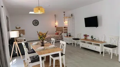 a living room and dining room with a table and chairs at Apartamentos Turísticos Antonio Parra in Jerez de la Frontera