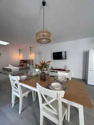 a dining room with a table and white chairs at Apartamentos Turísticos Antonio Parra in Jerez de la Frontera