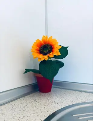 a red vase with a yellow flower in it at Casa Rural El Pequeño Oasis in Arcos de la Frontera
