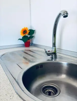 a kitchen sink with a vase with a sunflower in it at Casa Rural El Pequeño Oasis in Arcos de la Frontera