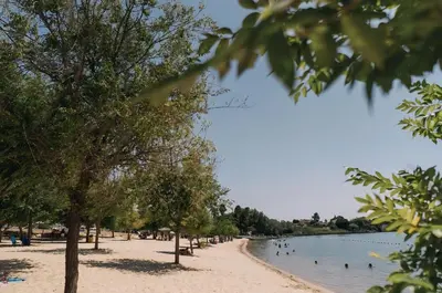 a beach with people and ducks in the water at Casa Rural El Pequeño Oasis in Arcos de la Frontera
