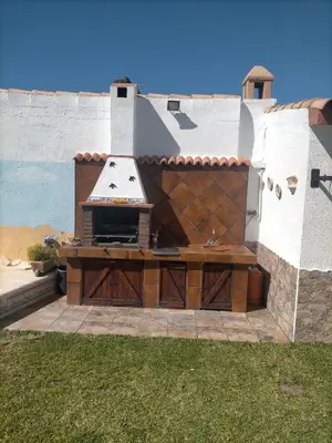 a bedroom with a large bed with a white comforter at Villa Mesana in Chiclana de la Frontera