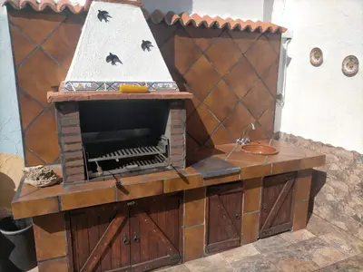 a wooden deck with a picnic table and an umbrella at Villa Mesana in Chiclana de la Frontera