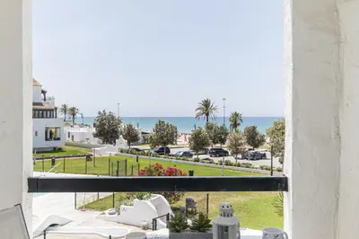 a view of the ocean from a room with a window at Pinomar, estupendo apartamento en primera línea de playa in Chiclana de la Frontera