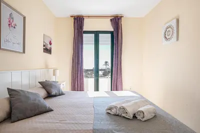 a bedroom with a bed with two pillows on it at Pinomar, estupendo apartamento en primera línea de playa in Chiclana de la Frontera
