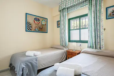 a bedroom with two beds and a window at Pinomar, estupendo apartamento en primera línea de playa in Chiclana de la Frontera