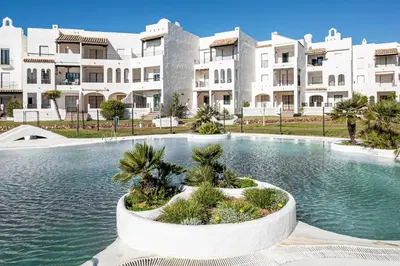 a swimming pool in front of a large building at Pinomar, estupendo apartamento en primera línea de playa in Chiclana de la Frontera