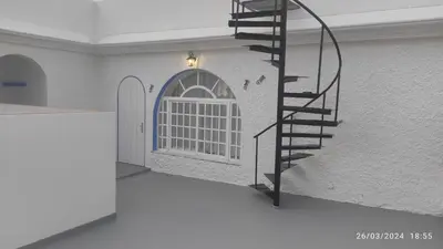 a spiral staircase in a room with a door at Ático en Chipiona in Chipiona