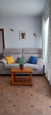 a living room with a couch and a coffee table at Ático en Chipiona in Chipiona