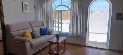a living room with a couch and a table at Ático en Chipiona in Chipiona