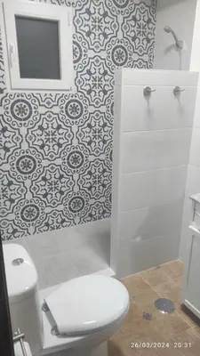 a bathroom with a white toilet and a mirror at Ático en Chipiona in Chipiona