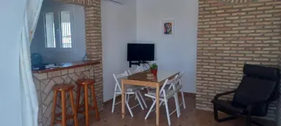 a dining room with a table and chairs and a television at Ático en Chipiona in Chipiona