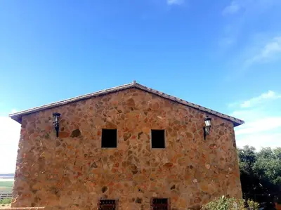 an old stone building with a blue sky in the background at Casa Rural El Almendrillo in Arcos de la Frontera