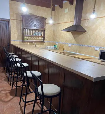 a row of stools at a bar in a restaurant at Casa Rural El Almendrillo in Arcos de la Frontera