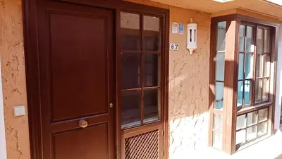 a brown door next to a window on a building at Apartamentos Jasmund - Bungalow 87 in San Fernando
