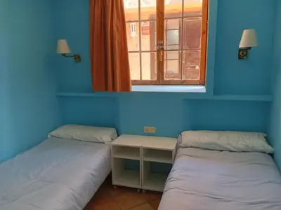 two beds in a room with a window at Apartamentos Jasmund - Bungalow 87 in San Fernando