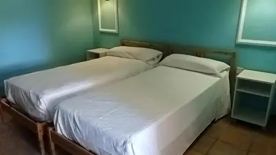 two twin beds in a room with green walls at Apartamentos Jasmund - Bungalow 87 in San Fernando
