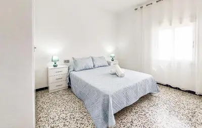 a white bedroom with a bed and a window at 2 Bedroom Stunning Apartment In Rota in Rota