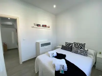a bedroom with a bed with black and white pillows at Chalet Benamejí in Sanlúcar de Barrameda