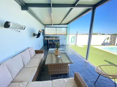 a living room with a white couch and a table at Chalet Benamejí in Sanlúcar de Barrameda
