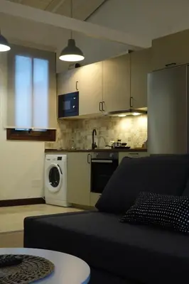 a living room with a couch and a kitchen at Apartamento Casa Dalí in Jerez de la Frontera